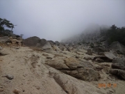 霧に包まれた山頂への砂礫登坂道