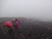 霧雨の中のツアー登山者の列